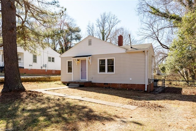 view of front of house with crawl space, a gate, a chimney, and fence