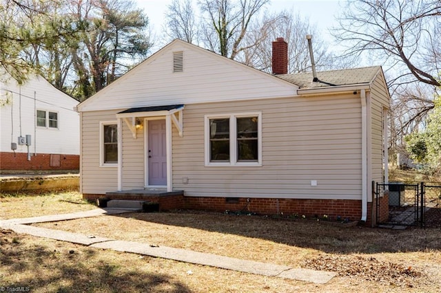 view of front facade with crawl space, a chimney, fence, and roof with shingles