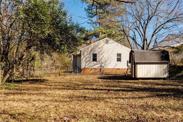 view of home's exterior with crawl space, a storage unit, a lawn, and an outbuilding