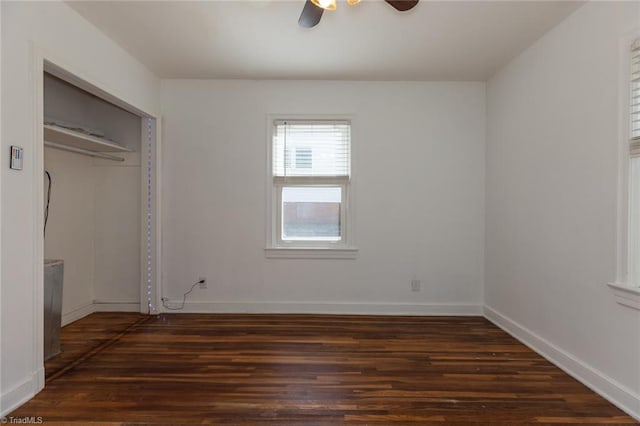 unfurnished bedroom with a ceiling fan, a closet, dark wood finished floors, and baseboards