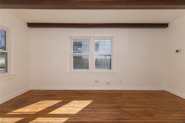 empty room with beamed ceiling, wood finished floors, and baseboards