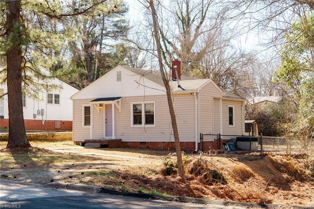 view of front of property featuring crawl space, a chimney, and fence