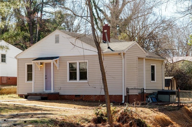 view of front facade with crawl space, roof with shingles, fence, and a chimney