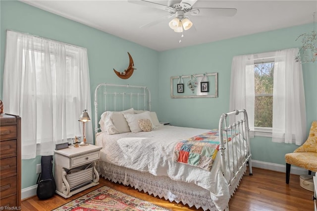 bedroom with wood finished floors, a ceiling fan, and baseboards