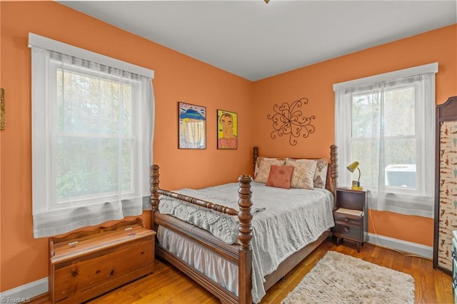 bedroom with baseboards and wood finished floors