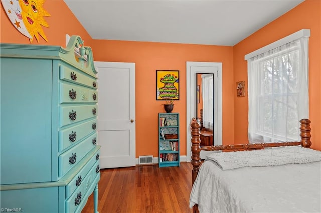 bedroom with dark wood-style flooring, visible vents, and baseboards