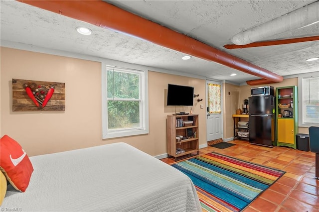 bedroom with a textured ceiling, recessed lighting, baseboards, freestanding refrigerator, and tile patterned floors