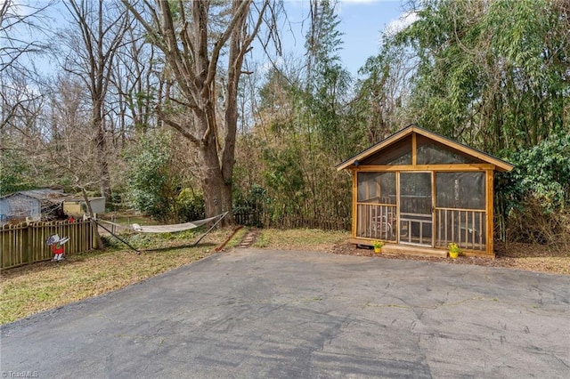 exterior space with a sunroom and fence