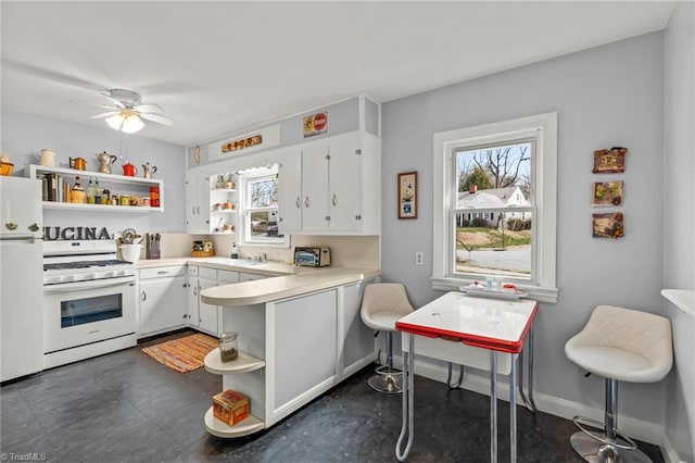 kitchen featuring white appliances, white cabinetry, a peninsula, and open shelves