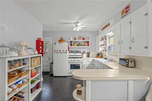 kitchen with white appliances, light countertops, white cabinetry, open shelves, and a sink