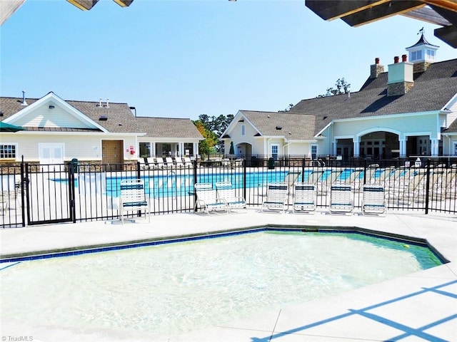 community pool featuring a patio area and fence