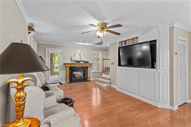 422 Wildwood Dr, Salisbury, NC 28146 - living room featuring light wood-type flooring, a textured ceiling, a ceiling fan, and ornamental molding