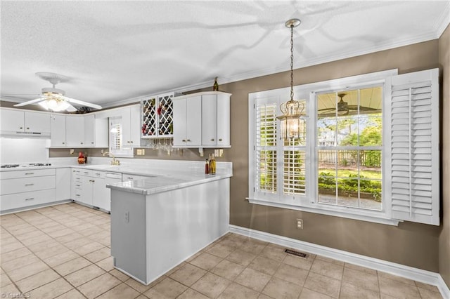 422 Wildwood Dr, Salisbury, NC 28146 - kitchen featuring a peninsula, light countertops, white cabinets, and ornamental molding