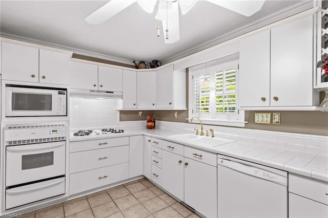422 Wildwood Dr, Salisbury, NC 28146 - kitchen with a sink, a warming drawer, white cabinetry, white appliances, and under cabinet range hood
