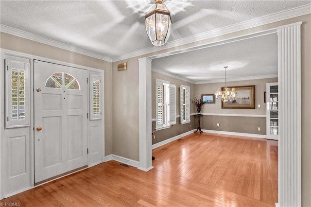 422 Wildwood Dr, Salisbury, NC 28146 - foyer entrance with a textured ceiling, an inviting chandelier, light wood-style flooring, baseboards, and visible vents