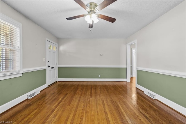 spare room featuring ceiling fan, wood-type flooring, and a textured ceiling