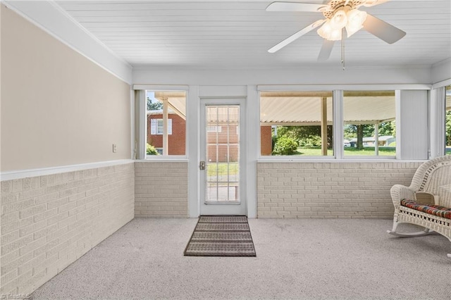 unfurnished sunroom featuring ceiling fan