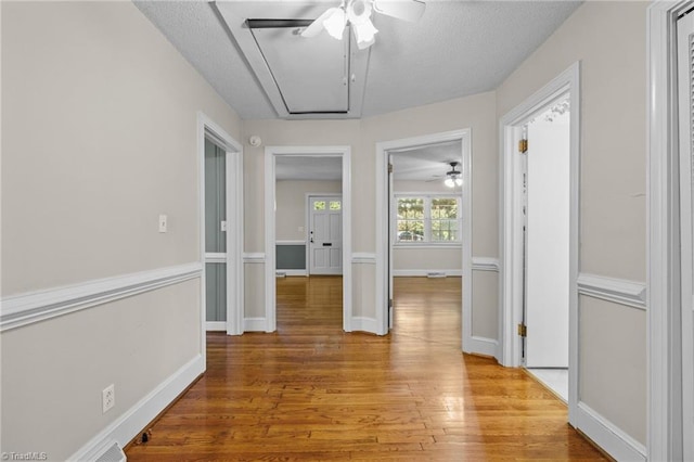 corridor with hardwood / wood-style floors and a textured ceiling