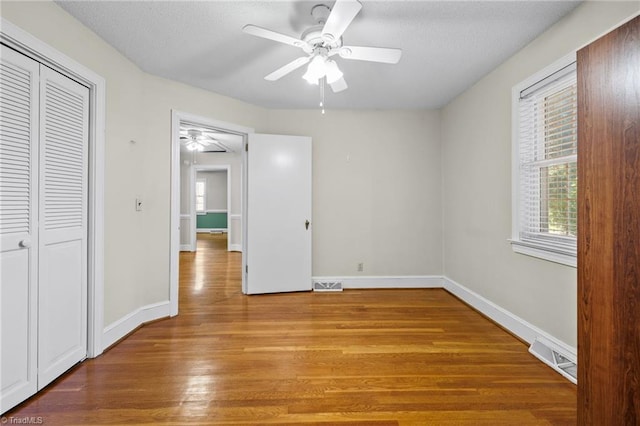 unfurnished bedroom with light wood-type flooring, a closet, and ceiling fan