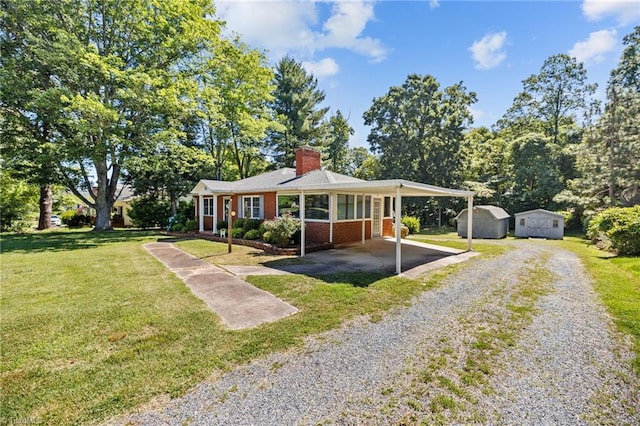 ranch-style house with a front lawn, a shed, and a carport