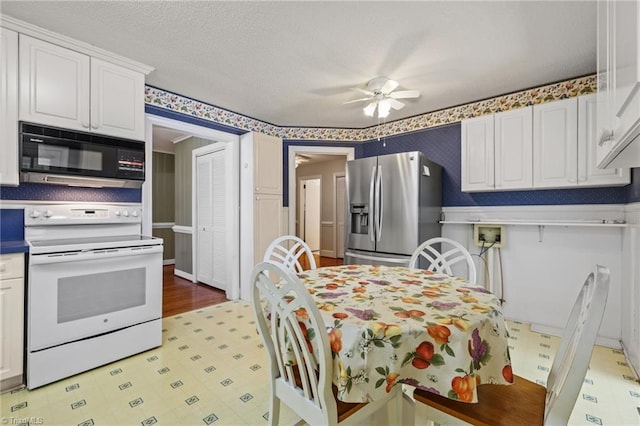 kitchen featuring ceiling fan, white range, white cabinets, and stainless steel refrigerator with ice dispenser