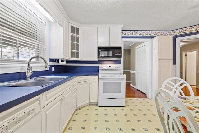 kitchen featuring white cabinets, a textured ceiling, white appliances, and sink