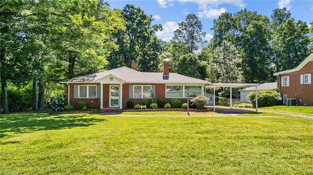 ranch-style house featuring a carport, central AC unit, and a front lawn