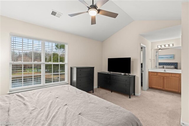 carpeted bedroom with ceiling fan, lofted ceiling, and connected bathroom