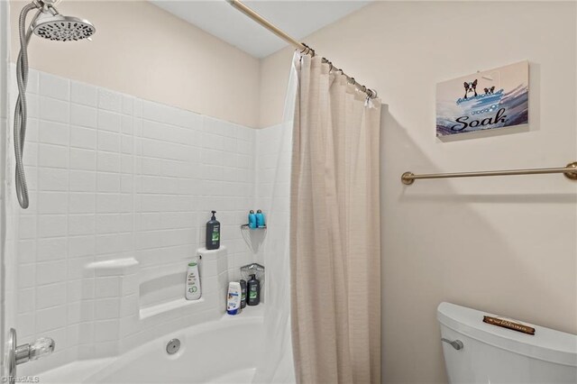 bathroom with toilet and shower / tub combo with curtain