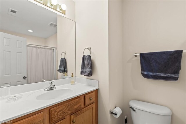 bathroom featuring a shower with curtain, vanity, and toilet