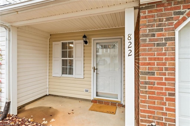 view of exterior entry featuring covered porch