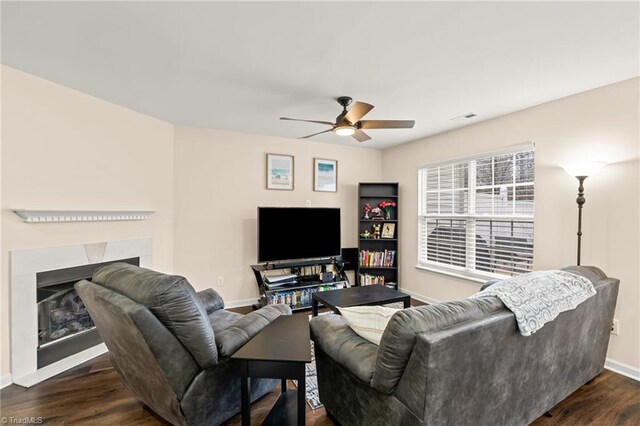 living room featuring ceiling fan and dark wood-type flooring