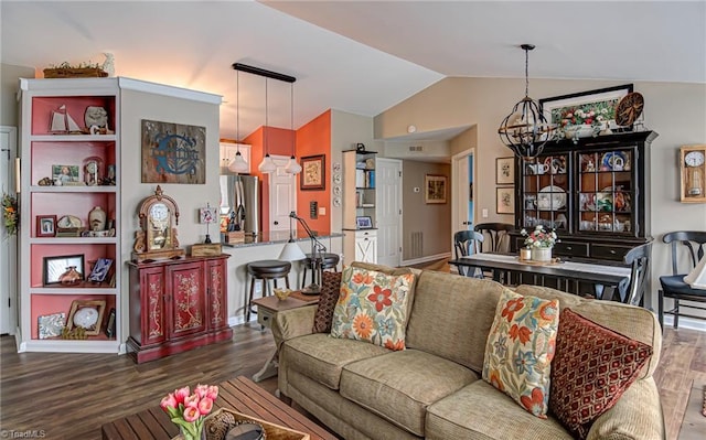 living room with lofted ceiling, dark wood-type flooring, and a chandelier