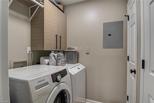 clothes washing area featuring washer and dryer, cabinets, and electric panel