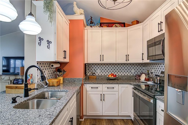 kitchen featuring white cabinets, appliances with stainless steel finishes, decorative light fixtures, and sink