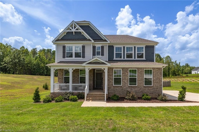 craftsman house featuring a front lawn, a porch, and brick siding