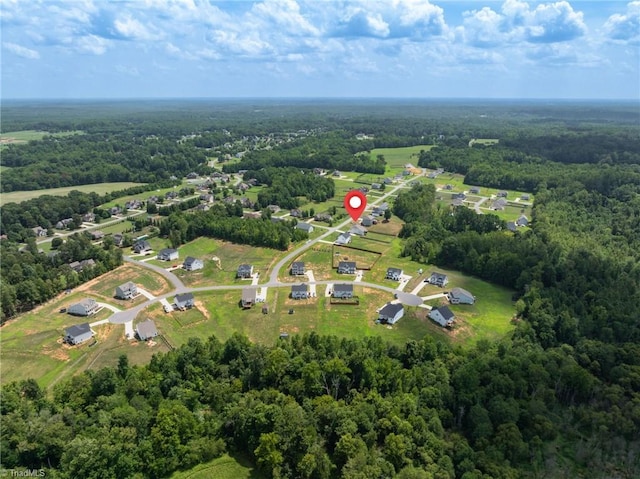 birds eye view of property featuring a wooded view