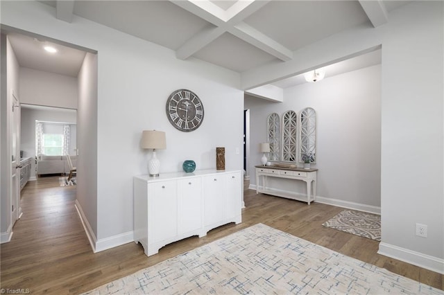 corridor with beam ceiling, baseboards, and wood finished floors