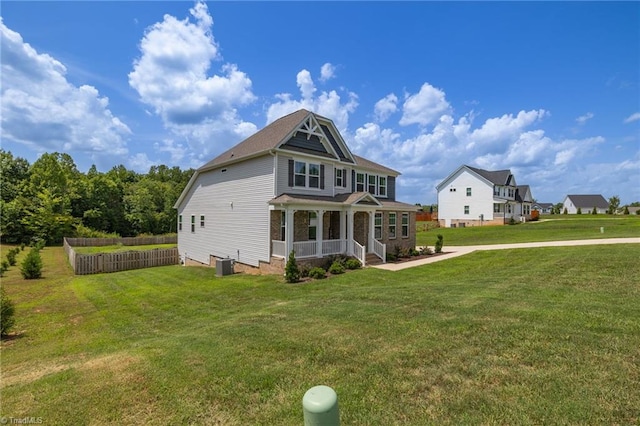 rear view of house featuring a porch, central AC, and a yard