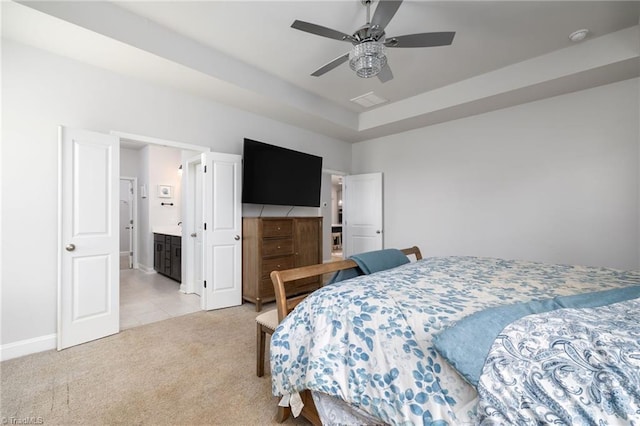 bedroom with connected bathroom, light tile patterned floors, and ceiling fan