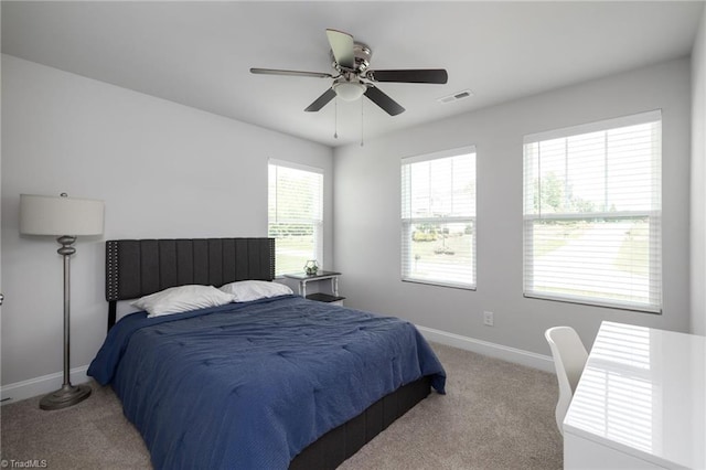 bedroom with baseboards, visible vents, a ceiling fan, and light colored carpet