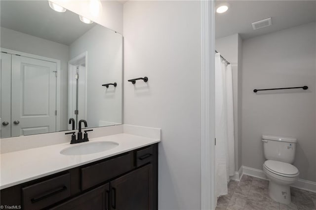 bathroom featuring vanity, toilet, and tile patterned flooring