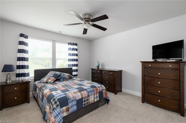 bedroom featuring light colored carpet, ceiling fan, visible vents, and baseboards