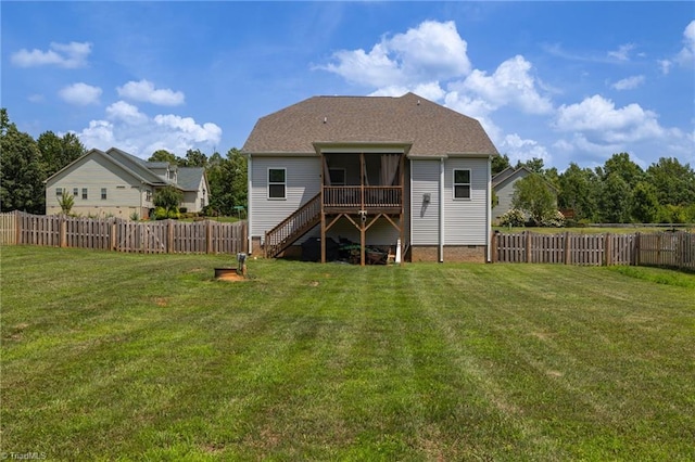 rear view of property featuring a sunroom and a lawn