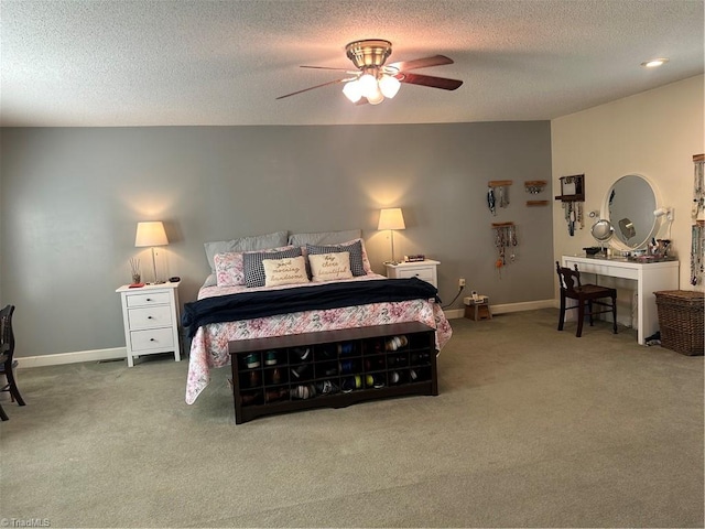 bedroom with ceiling fan, carpet floors, and a textured ceiling