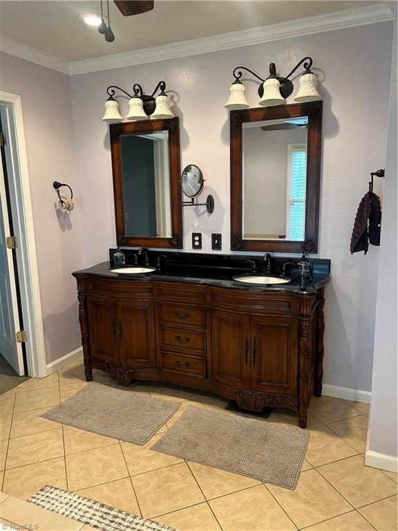 bathroom featuring crown molding, tile patterned floors, and vanity