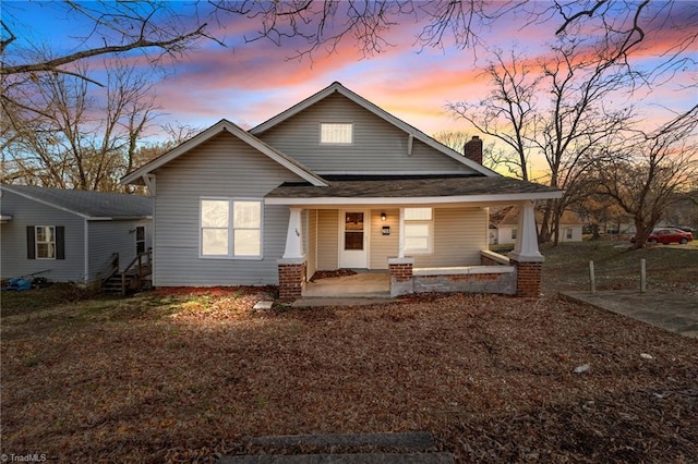 view of front of property featuring covered porch and a chimney