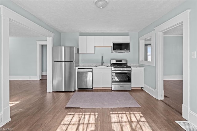 kitchen with white cabinetry, appliances with stainless steel finishes, light countertops, and a sink