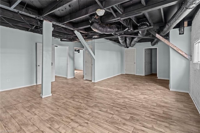 unfinished basement featuring baseboards and wood finished floors