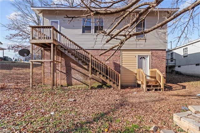 rear view of property with brick siding and stairway